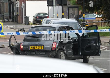 Clevedon Road, Birmingham, 17 mai 2024 - la police des West Midlands a fermé plusieurs routes dans la région de Balsall Heath à Birmingham après une poursuite policière qui a conduit le conducteur en fuite d'une Nissan Micra à s'écraser sur un autre véhicule. Un occupant masculin du Micra a été grièvement blessé et emmené à l'hôpital en état d'arrestation. Deux autres hommes ont fui la scène, l'un a été arrêté peu de temps après et l'autre est exceptionnel. Les officiers ont inondé le secteur de Clevedon Road et Lincoln Street en mettant en place un grand cordon. Un entraîneur pour homme et une veste noire ainsi que les premiers soins pouvaient être vus sur la route à une croix piétonne Banque D'Images