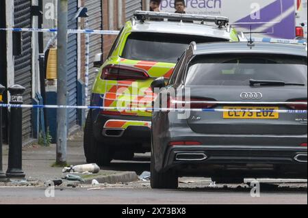 Clevedon Road, Birmingham, 17 mai 2024 - la police des West Midlands a fermé plusieurs routes dans la région de Balsall Heath à Birmingham après une poursuite policière qui a conduit le conducteur en fuite d'une Nissan Micra à s'écraser sur un autre véhicule. Un occupant masculin du Micra a été grièvement blessé et emmené à l'hôpital en état d'arrestation. Deux autres hommes ont fui la scène, l'un a été arrêté peu de temps après et l'autre est exceptionnel. Les officiers ont inondé le secteur de Clevedon Road et Lincoln Street en mettant en place un grand cordon. Un entraîneur pour homme et une veste noire ainsi que les premiers soins pouvaient être vus sur la route à une croix piétonne Banque D'Images