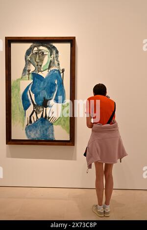 Exposition « L’écho de Picasso » dans la galerie d’art du Musée Picasso, Málaga, Espagne, visiteur regardant des peintures de Picasso « femme assise » Banque D'Images