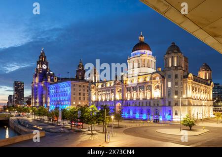 La nuit tombe aux Three Graces sur le front de mer de Liverpool, en Angleterre. Banque D'Images