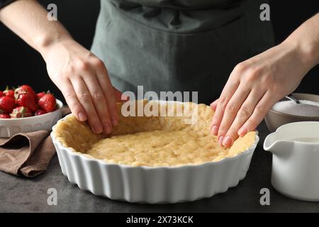 Pâte brisée. Femme faisant une tarte à la table grise, gros plan Banque D'Images