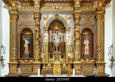 L'autel de style baroque, en bois sculpté et doré avec trois statues dans le rond dans l'église de San Rocco à Castel del Monte. Abruzzes, Italie Banque D'Images