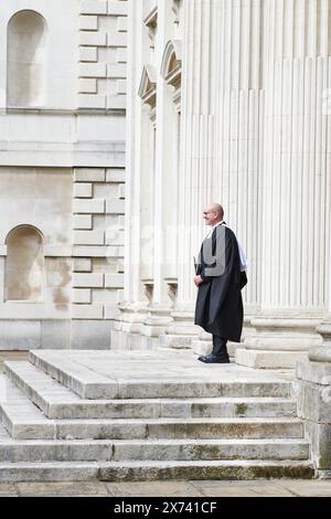 Un étudiant diplômé, en tenue académique, de l'Université de Cambridge, en Angleterre, célèbre son succès académique sur les marches de la Chambre du Sénat, vendredi 17 mai 2024. Banque D'Images