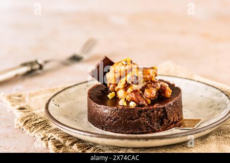 Tartelette au chocolat avec garniture de noix caramélisées, amandes et pistaches, espace copie Banque D'Images