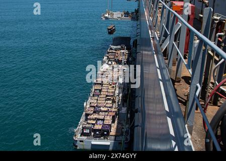 Le 14 mai 2024 - Ashdod, Israël - L'aide humanitaire est levée par une grue actionnée par des soldats affectés à la 7e Brigade de transport (expéditionnaire) d'une chaussée de la marine au port d'Ashdod, en Israël. Ces soldats soutiennent la construction du système conjoint logistique Over-the-Shore au large de Gaza. À la demande de l'Agency for International Development des États-Unis, le quai temporaire, appelé joint Logistics Over-the-Shore Capacity, aidera la communauté humanitaire à acheminer l'aide humanitaire internationale aux citoyens de Gaza dans le besoin par l'intermédiaire des Humani Banque D'Images