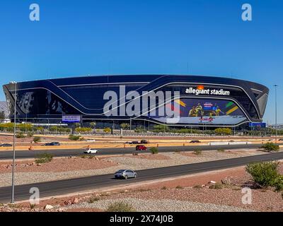 Las Vegas, NV, États-Unis - 12 mai 2024 : stade Black Allegiant derrière l'interstate 15 avec panneau international de football sous le ciel bleu. Parking vide, voitures allumées Banque D'Images