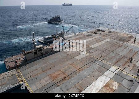 1er mai 2024 - mer Méditerranée - soldats de l'armée américaine affectés à la 7e brigade de transport (expéditionnaire) et marins de l'US Navy affectés au bataillon de construction amphibie 1, et embarqués à bord de l'USNS 1st Lt. Baldomero Lopez, sécurisent le Roll-on, Roll-Off distribution Facility, ou jetée flottante, sur le côté du MV Roy P. Benavidez, au large de la côte de Gaza, 1er mai 2024. À la demande de l'Agency for International Development des États-Unis, le quai temporaire, appelé joint Logistics Over-the-Shore Capacity, aidera la communauté humanitaire à livrer des secours internationaux Banque D'Images