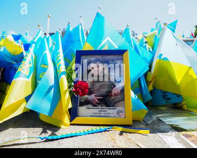 Portrait d'un militaire ukrainien avec une mitrailleuse dans les mains parmi des drapeaux portant les noms des personnes tuées pendant la guerre. L’inscription en ukrainien : “Afanasyev Ivan “Afonya”. Forces des opérations militaires » les dates de la vie du guerrier sont également indiquées. Selon diverses estimations, le nombre de soldats ukrainiens tués pendant le conflit est estimé de 70 à 120 mille personnes ; les pertes totales au combat pourraient être d'environ 300 mille. Le président Vladimir Zelensky affirme que le nombre de soldats ukrainiens morts est de 31 mille. Banque D'Images