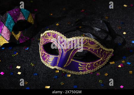 Masque de carnaval avec confetties sur fond noir. Banque D'Images