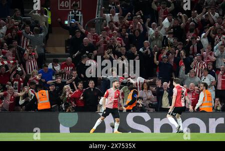 Adam Armstrong de Southampton (au centre) célèbre avoir marqué le deuxième but de son équipe devant les supporters lors du match de deuxième manche en demi-finale du Sky Bet Championship au St Mary's Stadium de Southampton. Date de la photo : vendredi 17 mai 2024. Banque D'Images