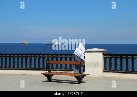 Femme sur le front de mer d'Alger regardant au-dessus de la Méditerranée Banque D'Images