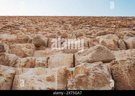 Vue rapprochée vers le haut des blocs de calcaire altérés de la Grande Pyramide de Gizeh, montrant son échelle massive et sa construction ancienne en pierre Banque D'Images