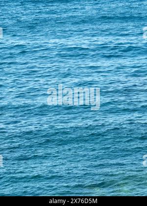 Fond vertical bleu foncé ondulations de la mer. Surface de la mer ridée par le vent. Toile de fond aquatique. Texture aquatique. Papier peint esthétique pour téléphone portable. Banque D'Images