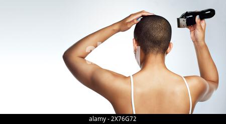 Tête, outil et femme rasant les cheveux pour le traitement du cancer, le bien-être et la chimiothérapie en studio. Personne féminine, machine et chauve pour la confiance avec Banque D'Images