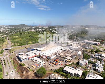 Vue aérienne du centre commercial Kenu-in à Dumbea, Nouvelle-Calédonie, 18 mai 2024. Une autre personne a été tuée samedi et deux autres blessées dans le territoire français Pacifique de la Nouvelle-Calédonie alors que le personnel de sécurité tentait de rétablir l'ordre après une cinquième nuit d'émeutes et de pillages qui a maintenant coûté la vie à six personnes. Pendant près d'une semaine, la ville habituellement tranquille de bord de mer a été convulsée. Deux gendarmes ont été tués : un coup de feu à la tête et un second coup de feu ami, ont indiqué les responsables. Trois autres personnes, toutes des Kanaks autochtones, ont également été tuées : un jeune de 17 ans et deux hommes âgés de 20 et 36 ans. Les troubles Banque D'Images