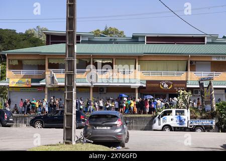 Samedi 18 mai 2024 - Dumbea - file d'attente devant la boulangerie de Koutio une autre personne a été tuée samedi et deux autres blessées dans le territoire français Pacifique de Nouvelle-Calédonie alors que le personnel de sécurité tentait de rétablir l'ordre après une cinquième nuit d'émeutes et de pillages qui a maintenant coûté la vie à six personnes. Pendant près d'une semaine, la ville habituellement tranquille de bord de mer a été convulsée. Deux gendarmes ont été tués : un coup de feu à la tête et un second coup de feu ami, ont indiqué les responsables. Trois autres personnes, toutes des Kanaks autochtones, ont également été tuées : un jeune de 17 ans et deux hommes âgés de 20 et 36 ans. Les troubles ont été b Banque D'Images