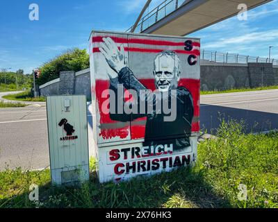 Freiburg im Breisgau, Baden-Württemberg, Deutschland, Europa : Freiburg Trainer, Christian Streich auf einem Verteilerkasten als Graffiti - Straßenszene, Graffiti, Großer grauer Verteilerkasten, Porträt eines Mannes, erhobene arme, texte STREICH CHRISTIAN , rote und schwarze Buchstaben, kleinerer Kasten, Graffiti mit Hammer, Brücke, Zaun, Straße, Grünfläche, blauer Himmel, einige Wolken. *** Freiburg im Breisgau, Baden Württemberg, Allemagne, Europe entraîneur de Freiburg, Christian Streich sur une boîte de distribution comme graffiti scène de rue, graffiti, grande boîte de distribution grise, portrait d'un homme, élevé a Banque D'Images