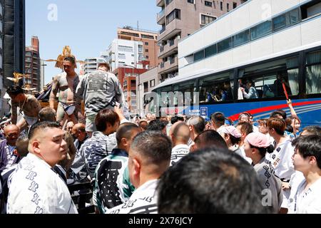 18 mai 2024, Tokyo, Japon : des touristes (R) prennent des photos d'un bus pour les participants du Sanja Matsuri montrant leur corps entier tatoué, peut-être des membres de la mafia japonaise ou Yakuza, dans le district d'Asakusa. Le Sanja Matsuri est l'un des plus grands festivals shinto de Tokyo, et il se tient dans le quartier Asakusa de Tokyo pendant trois jours autour du troisième week-end de mai. De grands groupes de personnes vêtues de vêtements traditionnels transportent des Mikoshi (sanctuaires sacrés portables) entre les rues près du temple Sensoji pour apporter bénédiction et fortune aux habitants de la communauté voisine à Asakusa pendant Banque D'Images