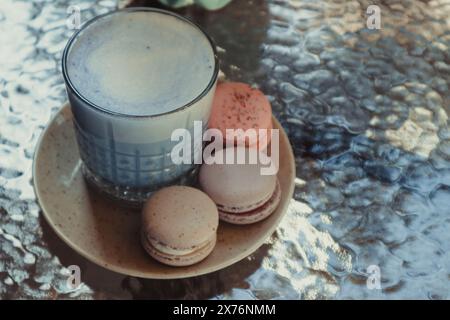 Savoureux biscuits macarons et latte matcha bleu sur table dans un café, style français. Détendez-vous et détendez-vous Banque D'Images