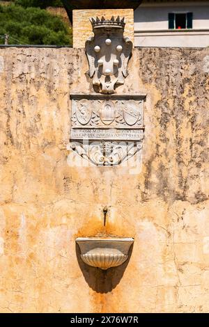 fontaine murale rustique avec crête médiévale Banque D'Images