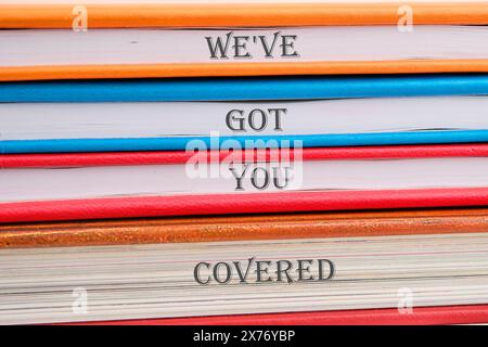 Signe de texte montrant We VE Got You Cover sur des cahiers empilés dans une pile Banque D'Images