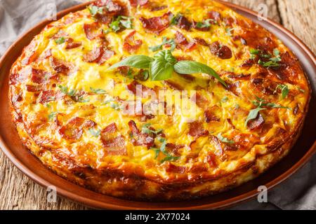 Savoureuse quiche sans croûte avec bacon, oeuf, poulet et fromage gros plan sur l'assiette sur la table en bois. Horizontal Banque D'Images