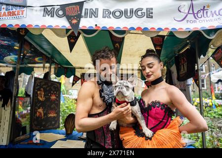 Londres, Royaume-Uni. 18 mai 2024. Les interprètes (avec la mascotte canine) du Moulin Rouge se tiennent au quatrième marché aux puces du West End dans les jardins de l’église St Paul, l’église des acteurs, à Covent Garden. Top West End Shows ont mis en place des stands au design unique pour célébrer leurs productions, ainsi que pour concourir pour le stand le mieux habillé. Des souvenirs théâtraux sont proposés au public dans le cadre d'un événement de collecte de fonds pour aider à jouer pour d'autres personnes, ce qui profite à 14 œuvres de théâtre et d'aide sociale britanniques. Credit : Stephen Chung / Alamy Live News Banque D'Images