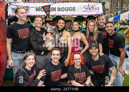 Londres, Royaume-Uni. 18 mai 2024. Les interprètes (avec la mascotte canine) du Moulin Rouge se tiennent au quatrième marché aux puces du West End dans les jardins de l’église St Paul, l’église des acteurs, à Covent Garden. Top West End Shows ont mis en place des stands au design unique pour célébrer leurs productions, ainsi que pour concourir pour le stand le mieux habillé. Des souvenirs théâtraux sont proposés au public dans le cadre d'un événement de collecte de fonds pour aider à jouer pour d'autres personnes, ce qui profite à 14 œuvres de théâtre et d'aide sociale britanniques. Credit : Stephen Chung / Alamy Live News Banque D'Images