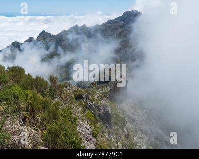 Vue depuis le Pico Ruivo le plus haut sommet de Madère, Portugal. Montagnes vertes, nuages brumeux et océan atlantique au sentier de randonnée PR1.2 de Achada Do Banque D'Images
