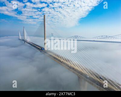 South Queensferry, Écosse, Royaume-Uni. 18 mai 2024. Vue aérienne du Queensferry Crossing Bridge et des deux autres Forth Bridges partiellement cachés par le brouillard marin du matin ou haar. Iain Masterton/Alamy Live News Banque D'Images