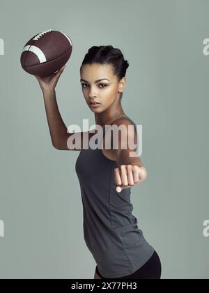 Américain, joueur de football et portrait de femme dans le sport sur fond de studio avec fitness dans le jeu. Athlète, entraînement et pratique féminine pour le match Banque D'Images