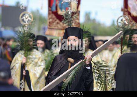 Des prêtres orthodoxes roumains tenant des feuilles de palmier marchent dans les rues de Bucarest lors d'une procession de pèlerinage le dimanche des Rameaux. Banque D'Images