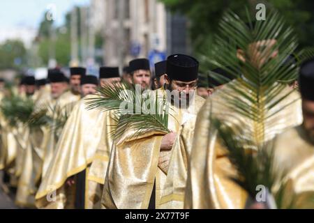 Des prêtres orthodoxes roumains tenant des feuilles de palmier marchent dans les rues de Bucarest lors d'une procession de pèlerinage le dimanche des Rameaux. Banque D'Images