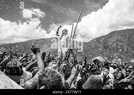 Un homme local fouette la foule à Un Mojon (c'est un endroit spécial qui est généralement un amas de rochers) pendant le Carnaval annuel, Maimara, Argentine. Banque D'Images