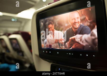 DOHA, QATAR - 15 DÉCEMBRE 2023 : un siège Qatar Airways en classe économique équipé d'un système de divertissement à bord. Banque D'Images