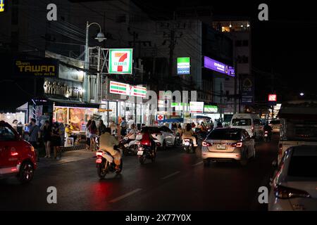 PHUKET, THAÏLANDE - 25 AVRIL 2023 : vue au niveau de la rue du magasin de proximité 7-Eleven et FamilyMart comme on le voit à Patong, Phuket la nuit. Banque D'Images