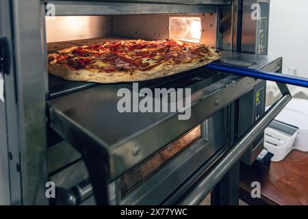 Cuisson de pizza fraîche dans un four professionnel Banque D'Images