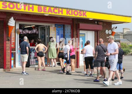 Troon, Royaume-Uni. 18 mai 2024. Les touristes et les habitants apprécient le temps chaud et ensoleillé à Troon Beach, South Ayrshire, en Écosse, malgré une brume marine ondulante, en milieu d'après-midi, venant du Firth of Clyde. Crédit : Findlay/Alamy Live News Banque D'Images