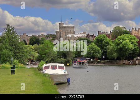 Château de Windsor la résidence Berkshire de la famille royale britannique vue depuis les rives de la Tamise à Eton et les avions volant au-dessus Banque D'Images