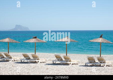 Vue sur la mer Méditerranée bleu turquoise et la plage balnéaire d'Albir dans la province d'Alicante, Espagne. Plage de Raco de Albir avec galets blancs, parasols et BE Banque D'Images