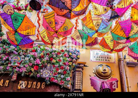 Nice, France - des parasols colorés suspendus à l'envers au-dessus d'une rue étroite fournissent de l'ombre sur les tables de l'un des restaurants en plein air Banque D'Images