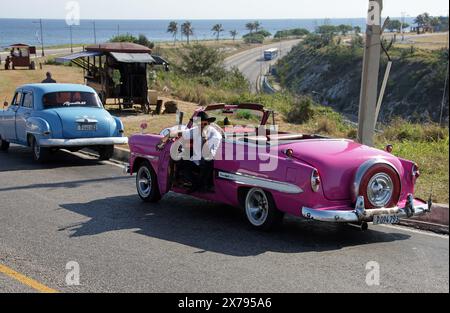 Rose 1953 Chevrolet Bel Air Convertible voiture classique utilisée comme taxi, Havana Harbour, Cuba, Caraïbes. Aussi, Blue Plymouth 52 Classic car. Banque D'Images