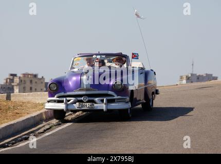 Voiture classique Pontiac violette des années 1950. Château de Morro / Castillo de los Tres Reyes Magos del Morro, Cuba, Caraïbes. Banque D'Images