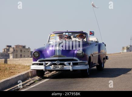 Voiture classique Pontiac violette des années 1950. Château de Morro / Castillo de los Tres Reyes Magos del Morro, Cuba, Caraïbes. Banque D'Images