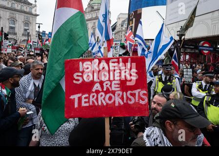 Londres, Royaume-Uni. 18 mai 2024. Les partisans de la Palestine passent devant un petit groupe de sionistes alors qu'ils marchent de près du siège de la BBC à Whitehall pour commémorer le 76ème anniversaire de la Nakba - l'arabe pour «catastrophe» - qui a vu 750 000 Palestiniens chassés en exil, et appeler à un cessez-le-feu et à la fin du soutien britannique à la guerre en cours d'Israël contre Gaza. Depuis octobre 2023, lorsque des militants du Hamas ont attaqué Israël depuis la bande de Gaza assiégée, plus de 30 000 Palestiniens auraient été tués par Israël. Crédit : Ron Fassbender/Alamy Live News Banque D'Images