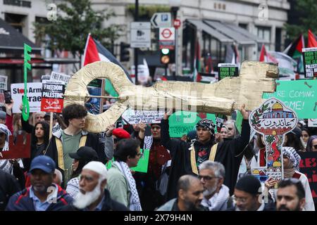 Une clé géante, symbolisant le droit du peuple palestinien au retour, est portée alors que des centaines de milliers de manifestants pro-palestiniens défilaient dans les rues de Londres à l’occasion du 76e anniversaire de la Nakba, exigeant un cessez-le-feu maintenant, l’arrêt de l’armement d’Israël et la fin du siège de Gaza. Nakba signifie « la catastrophe » et désigne le moment où 750,000 Palestiniens ont été forcés de quitter leurs maisons et contraints de fuir vers les pays voisins par les forces israéliennes au moment de la création d’Israël en 1948. La marche a été paisible et s'est terminée par un rassemblement à Whitehall. Banque D'Images