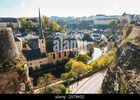Vue panoramique sur l'abbaye de Neumünster et la rivière Alzette serpentant à travers le quartier Grund de la ville de Luxembourg, encadrée par des falaises et des bâtiments historiques. Banque D'Images