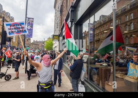 Leeds, Royaume-Uni. 18 MAI 2024. Le manifestant Pro Palestine se tient devant McDonalds sur Briggate dans le centre de Leeds dans le cadre du boycott de la chaîne de restauration rapide lors de la marche standard PSC de Leeds dans le centre-ville. Crédit Milo Chandler/Alamy Live News Banque D'Images