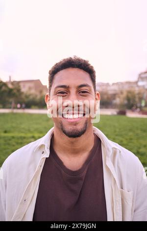 Bel homme barbu heureux. Portrait de jeune homme joyeux debout dehors et souriant à la caméra. Banque D'Images