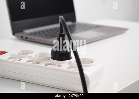 Fiche électrique dans la prise de courant à la maison. Prise, prise électrique, câble d'alimentation, équipement électrique, fils électriques et barrettes d'alimentation dans la maison Banque D'Images